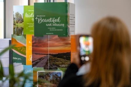 Person taking photo of a display of images of landscapes